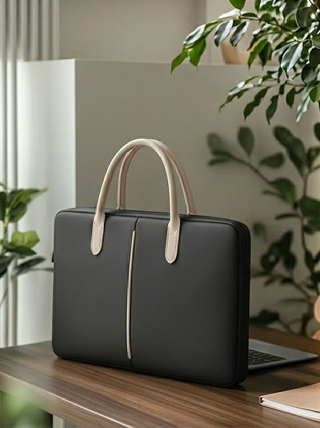 Travessary Handy Safe 14 inch laptop sleeve in black with beige handles on a wooden desk.